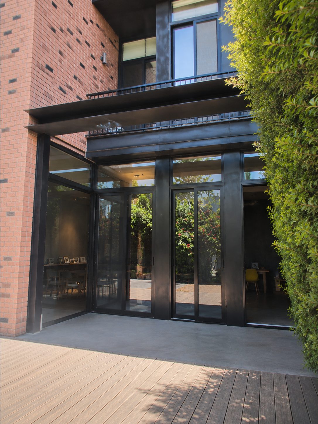 Steel-framed glass entrance and sliding doors of a brick villa